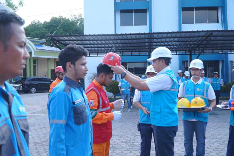 Senior Manager Distribusi, Hariadi Fotrianto saat memasangkan Helm kepada pengawas Pekerjaan sebagai wujud penerapan budaya safety.