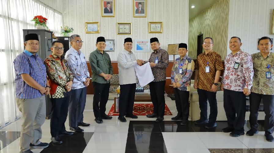 Plt Dirut Perumda Tirtanadi, Ewin Putra menyerahkan menyerahkan handuk untuk Jemaah Haji Embarkasi Medan pada musim haji tahun 2025, di Asrama Haji Medan Jalan Jenderal Abdul Haris Nasution, Jumat (25/4/2025).