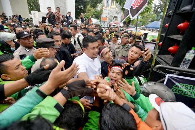Gubernur Sumatera Utara (Sumut) Muhammad Bobby Afif Nasution menemui dan mendengarkan keluhan para driver ojek online (Ojol) roda dua, yang melakukan unjuk rasa di depan Kantor Gubernur Sumut, Jalan Diponegoro 30 Medan, Selasa (20/5). Gabungan Ojek Roda Dua Medan Sekitar (GODAMS) yang menggelar ‘Aksi Damai 205’ memprotes kebijakan aplikator yang dianggap merugikan para driver online.