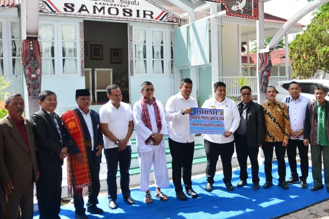 Gubernur Sumatera Utara (Sumut) Muhammad Bobby Afif Nasution menyerahkan aset Pemerintah Provinsi (Pemprov) kepada Bupati Kabupaten Samosir Vandiko Gultom berupa bangunan yang selama 21 tahun digunakan sebagai Rumah Dinas Bupati, di Pangururan, Samosir, Minggu (6/7/2025). Foto/Diskominfo Sumut