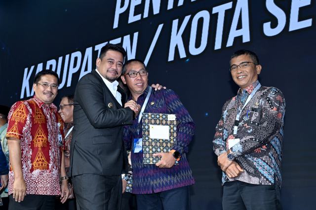 Gubernur Sumatera Utara (Sumut) Bobby Nasution didampingi Sekretaris Daerah Sumut Togap Simangunsong memberikan Dana Bagi Hasil (DBH) kepada Bupati/Walikota Se-Sumut Tahun 2025 di Aula Raja Inal Siregar, Jumat (8/8/2025). Foto/Diskominfo Sumut