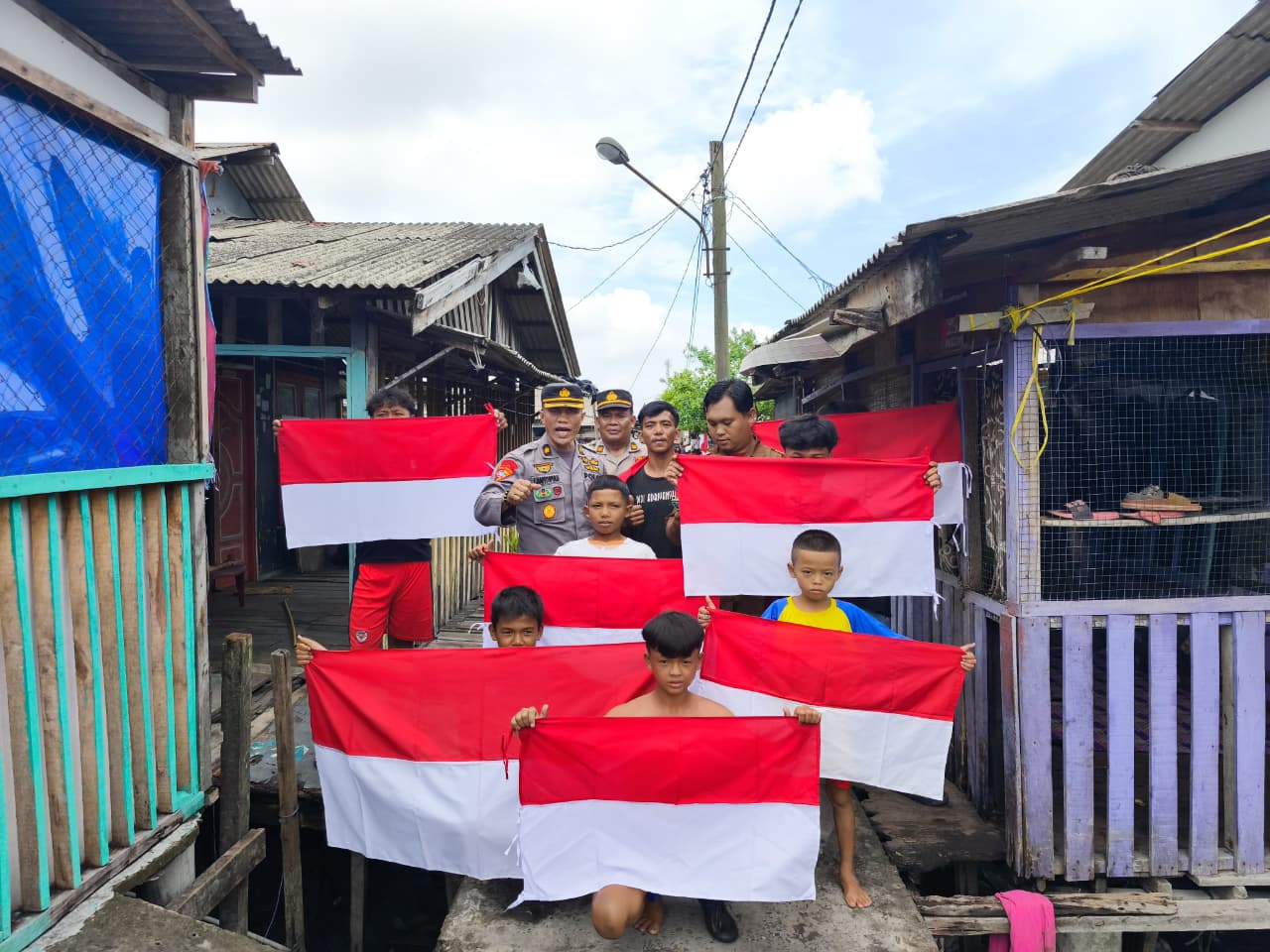 Sambut HUT Kemerdekaan, Polres Pelabuhan Belawan Bagikan Bendera Merah Putih