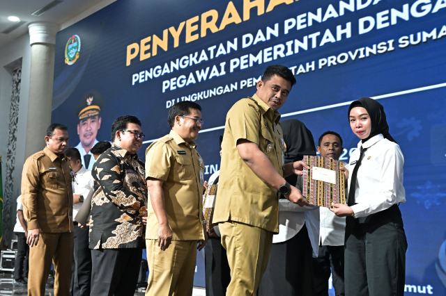 Gubernur Sumatera Utara (Sumut) Bobby Nasution menyerahkan surat keputusan (SK) pengangkatan Pegawai Pemerintah dengan Perjanjian Kerja (PPPK) di lingkungan Pemerintah Provinsi (Pemprov) Sumut. Acara penyerahan SK berlangsung di Aula Raja Inal Siregar, Kantor Gubernur, Jalan Diponegoro 30, Medan, Senin (22/9/2025). Foto/Diskominfo Sumut