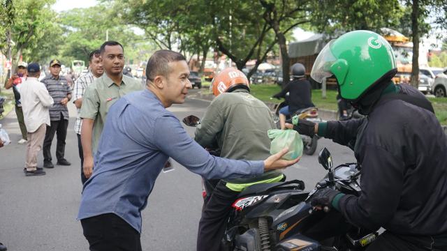 Kepala Bapenda Kota Medan, M. Agha Novrian, didampingi Sekretaris Badan T Roby Chairi serta para Kepala Bidang, menyerahkan paket nasi bungkus kepada para driver ojol yang melintas di depan Kantor Bapenda, Selasa (2/9/2025).