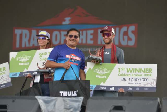 Sekretaris Daerah Provinsi Sumatera Utara (Sumut) Togap Simangunsong menyerahkan piala dan hadiah kepada para pemenang lari lintas alam Trail of The Kings Lake Toba by UTMB di panggung utama Waterfront Pangururan Kabupaten Samosir, Minggu (19/10/2025). Foto/Diskominfo Sumut