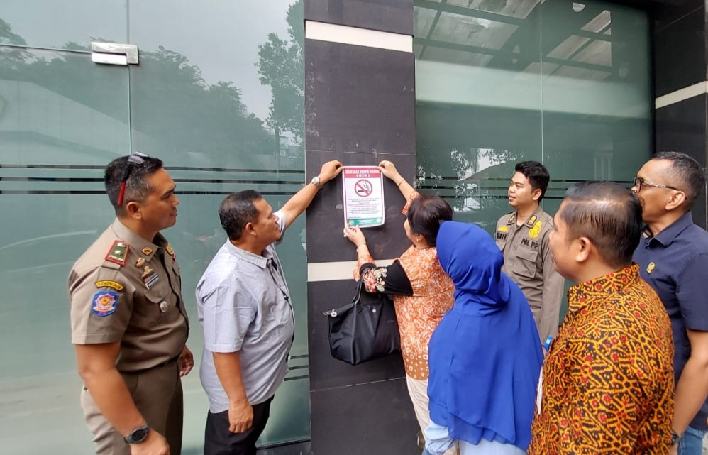 Pansus Ranperda tentang Kawasan Tanpa Rokok (KTR) DPRD Medan memasang stiker larangan merokok saat mengunjungi Kampus Universitas Sari Mutiara (USM) Indonesia di Kecamatan Medan Helvetia, Senin (13/10/2025).