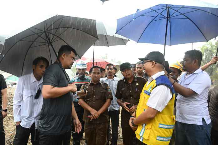 Di tengah hujan deras Gubernur Sumatera Utara (Sumut) Muhammad Bobby Afif Nasution didampingi Bupati tapanuli Tengah (Tapteng) Masinton Pasaribu meninjau proses pengerjaan pembangunan tanggul Sungai Tukka di Desa Hutanabolon, Kecamatan Tukka, Tapteng, Senin (13/4/2026).
