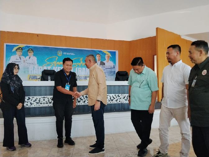 Penjabat (Pj) Sekretaris Daerah (Sekda) Provinsi Sumut Sulaiman Harahap menyematkan tanda peserta Raker Forum Wartawan Pemprovsu (FWP) di Parapat, Sabtu (27/6/2026). Foto/medandaily.com